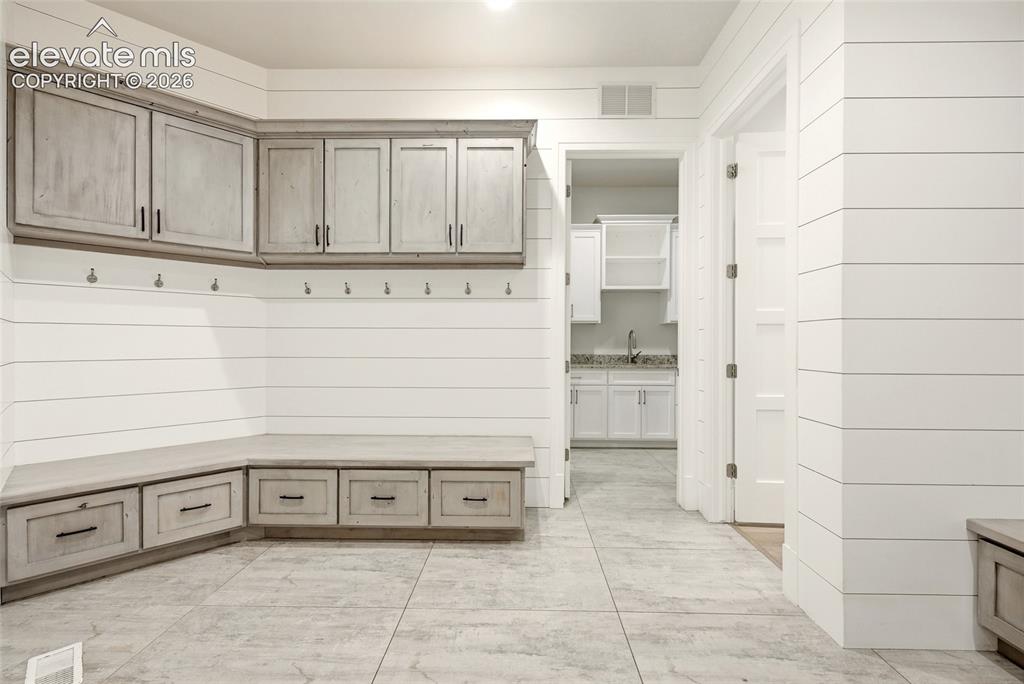 Image 27 of 50: Built-in cabinetry with distressed wood-finish doors and dark hardware, shi