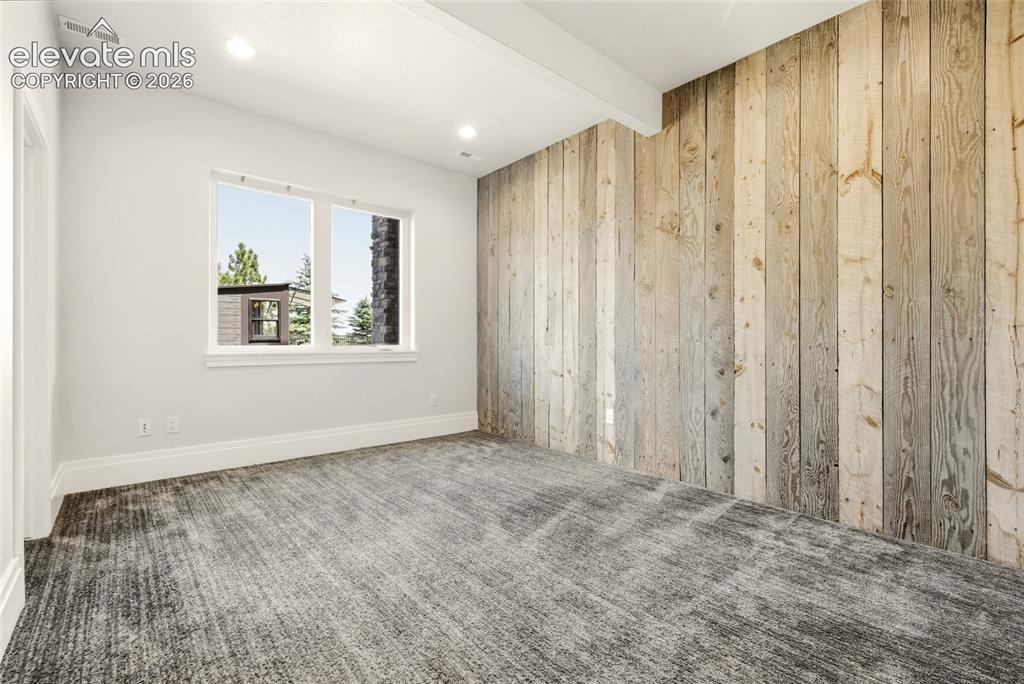 Image 31 of 50: Room featuring a prominent wood-panel accent wall, two large windows, reces