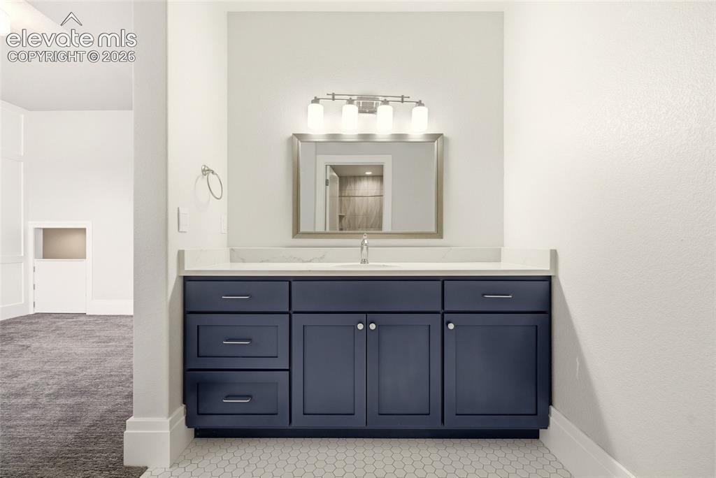 Image 33 of 50: Modern vanity featuring blue cabinetry, a white countertop, and a rectangul