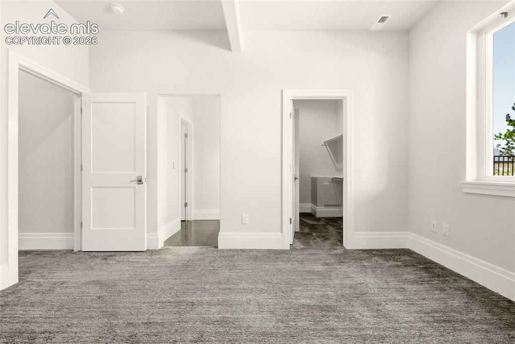 Image 36 of 50: Spacious room featuring plush gray carpeting, white trim, and light-colored