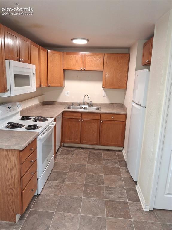 Image 2 of 10: Kitchen featuring wood cabinetry, laminate countertops, a stainless steel s