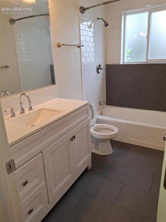 Image 4 of 10: Bathroom featuring a white vanity with integrated sink, chrome fixtures, su