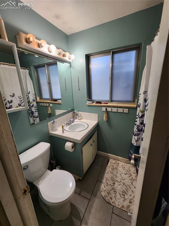 Image 11 of 33: Bathroom #1 with a shower with curtain, vanity, and tile patterned flooring