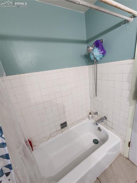 Image 12 of 33: Bathroom #1 featuring shower / tub combo with curtain and wood finished flo