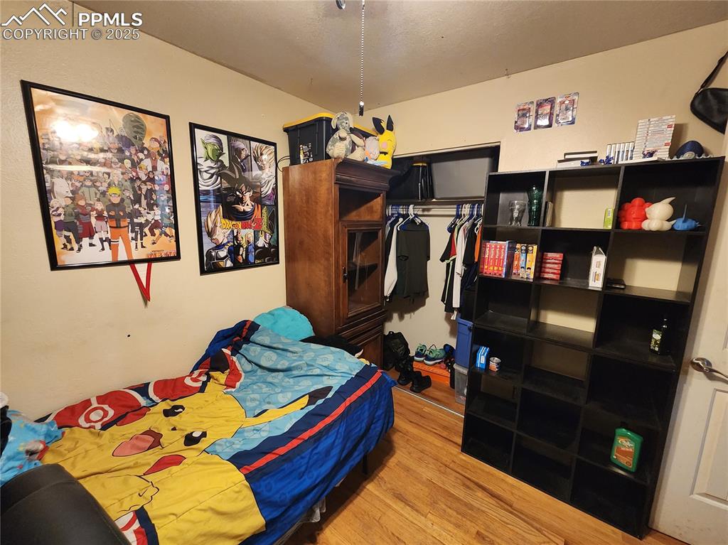 Image 14 of 33: Bedroom #2 featuring wood floors, ceiling fan and a closet