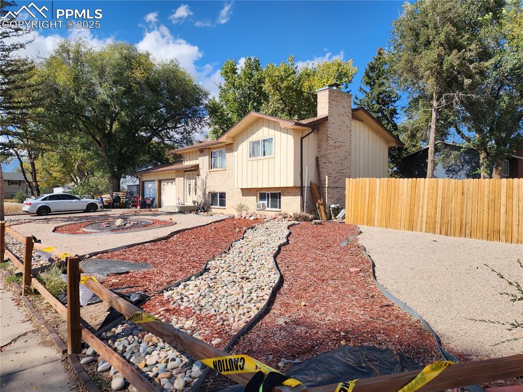 Image 3 of 33: View of front of property with brick siding, driveway, an attached garage, 