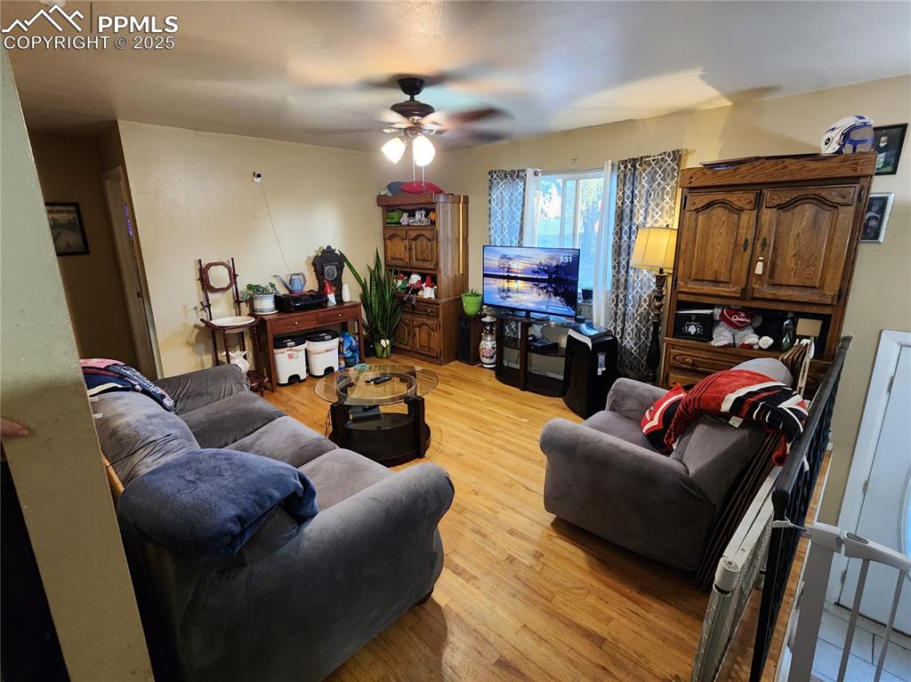 Image 6 of 33: Living area featuring wood floors and a ceiling fan