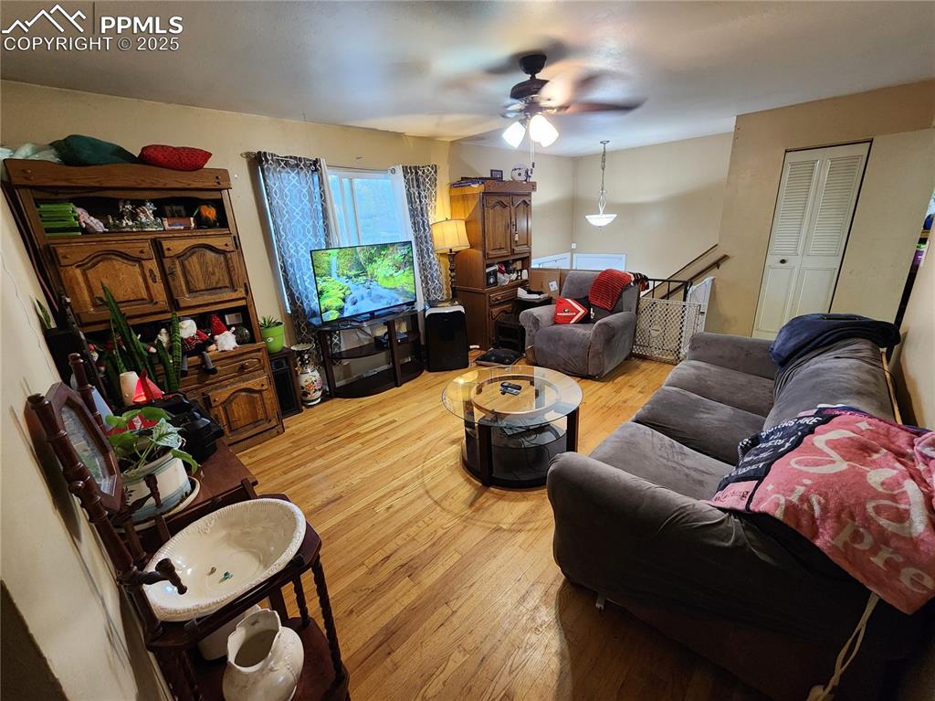 Image 7 of 33: Living area featuring wood floors and ceiling fan