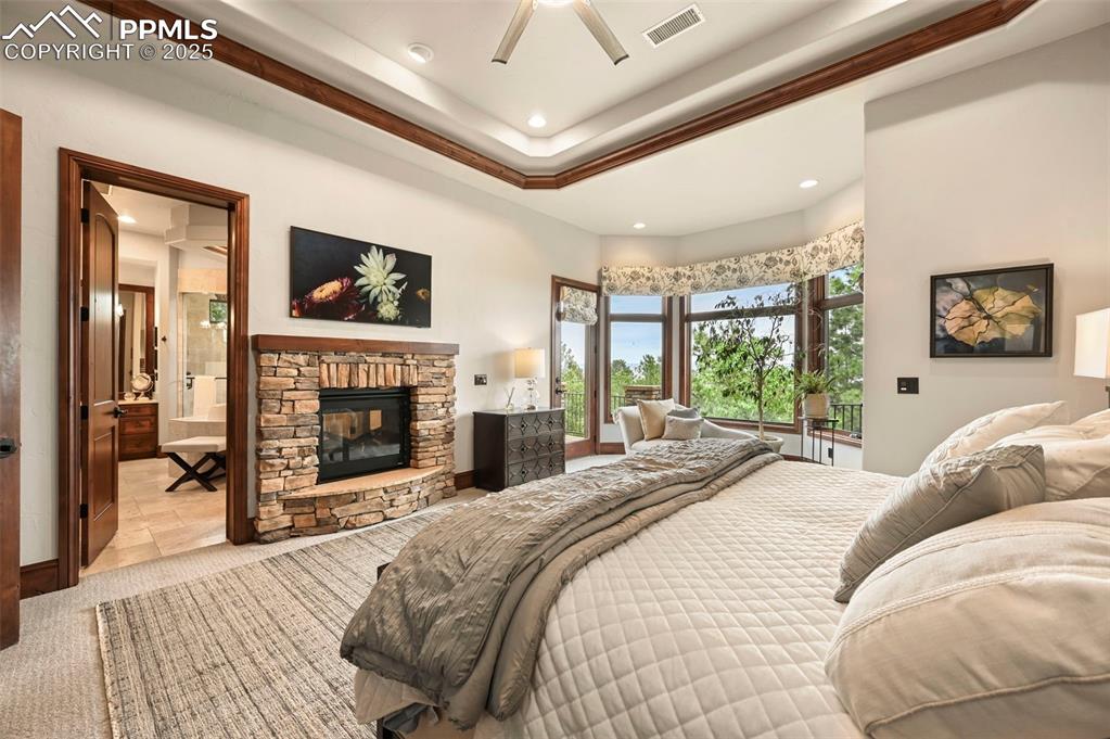 Image 18 of 50: The primary suite with fireplace and large Frame TV