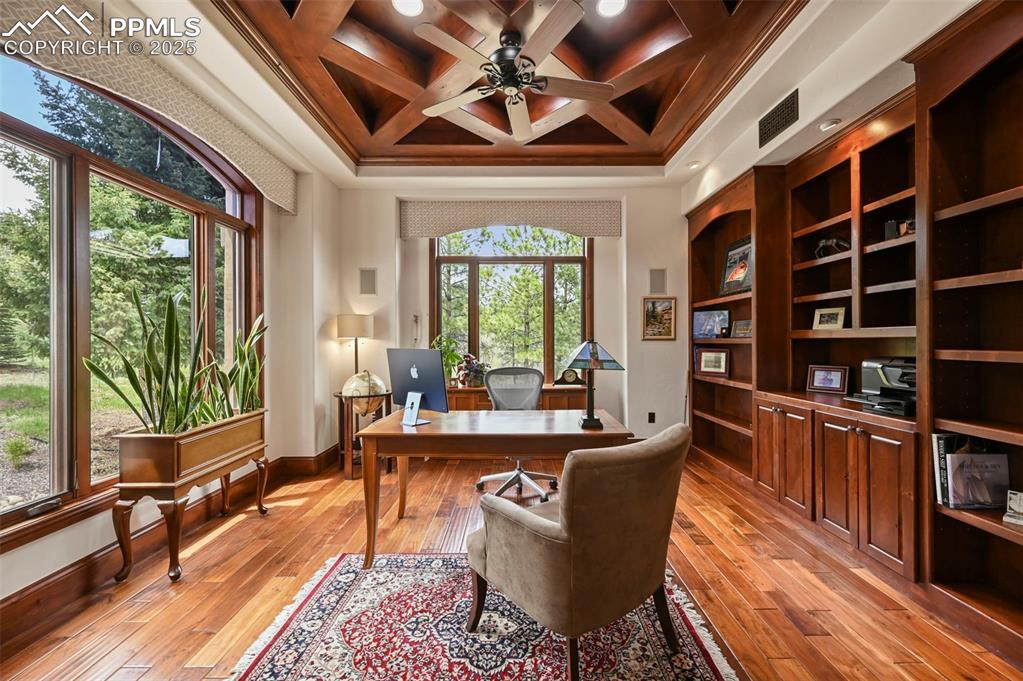 Image 6 of 50: Main level office with built-ins and wood detailed ceiling