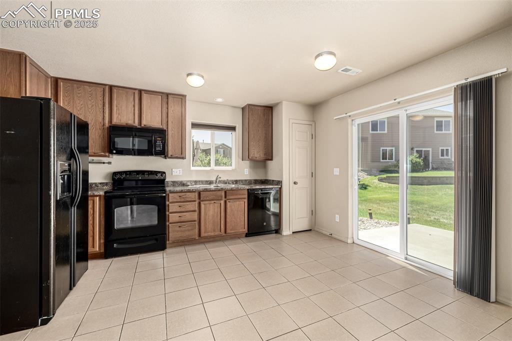 Image 7 of 30: The eat in kitchen features a walk out to the back patio