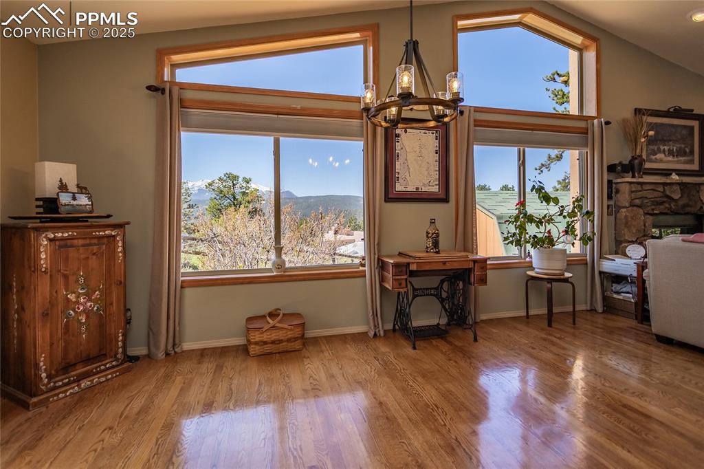Image 10 of 44: Dining room featuring Pikes Peak view, a chandelier, wood floors, vaulted c