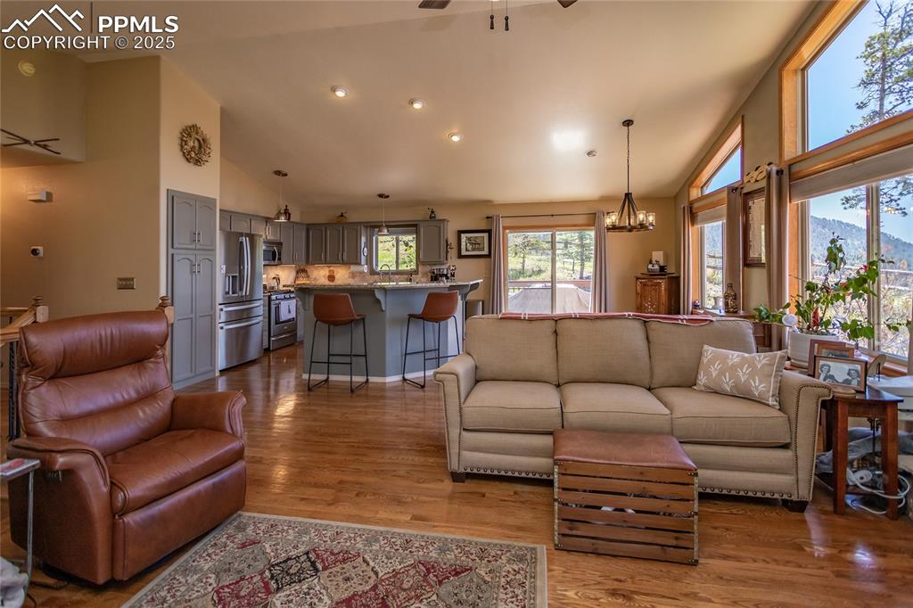 Image 11 of 44: Living area with a mountain view, high vaulted ceiling, wood floors
