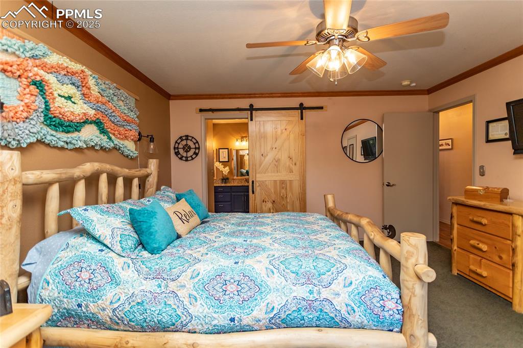 Image 17 of 44: Bedroom with a barn door into ensuite bathroom