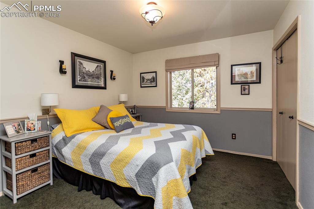 Image 22 of 44: Upper level Bedroom with serene treed view