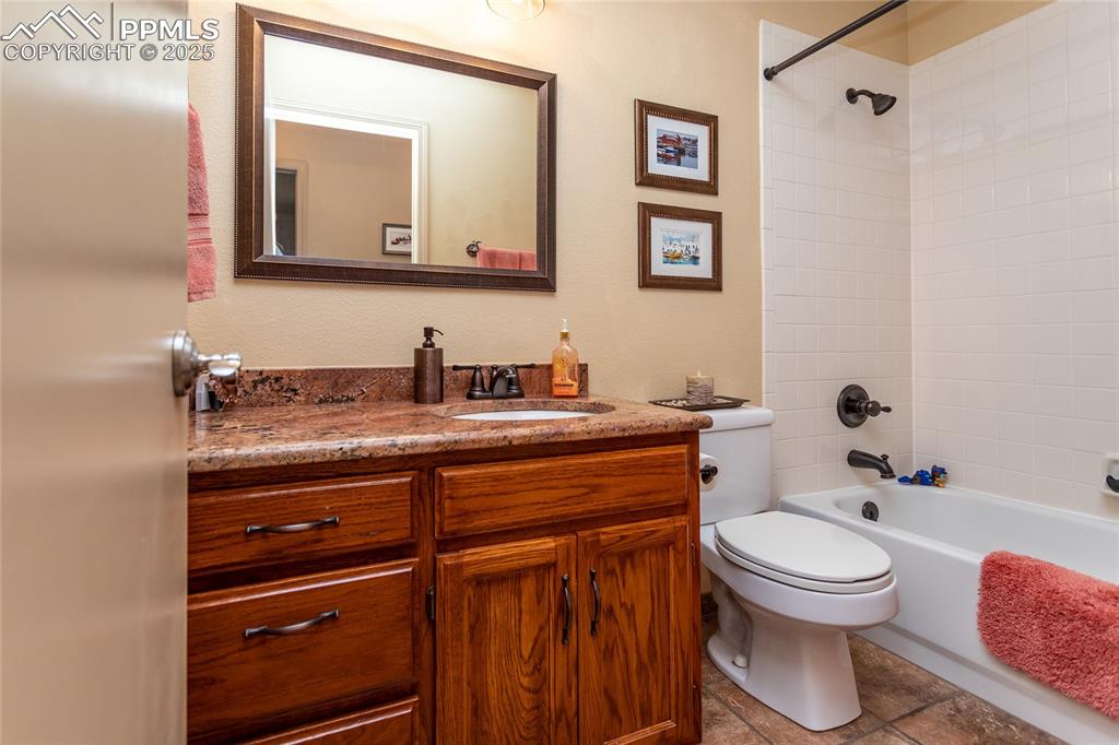 Image 25 of 44: Upper level guest Bathroom featuring vanity, toilet, and bathing tub/shower