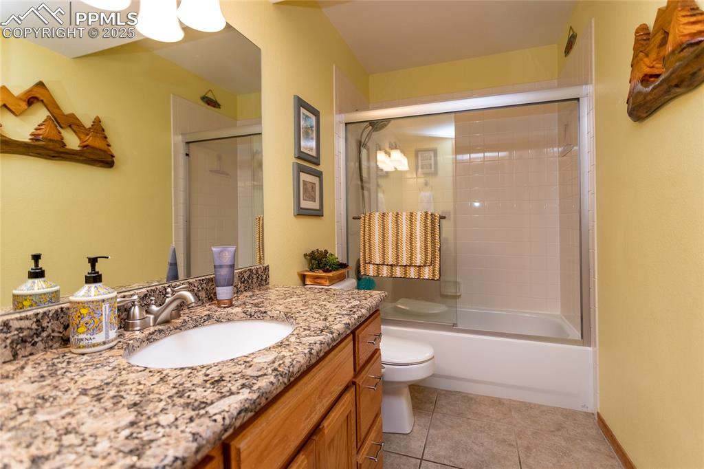 Image 28 of 44: Lower level Full bathroom featuring vanity, toilet, combined bath/shower wi