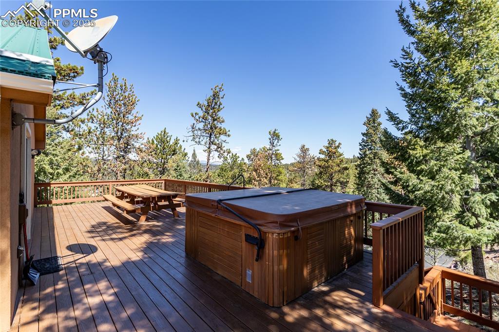 Image 40 of 44: Wooden deck off of the primary suite with a hot tub