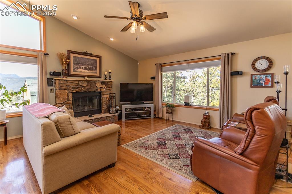 Image 8 of 44: Living room featuring vaulted ceiling, ceiling fan, gas fireplace, beautifu