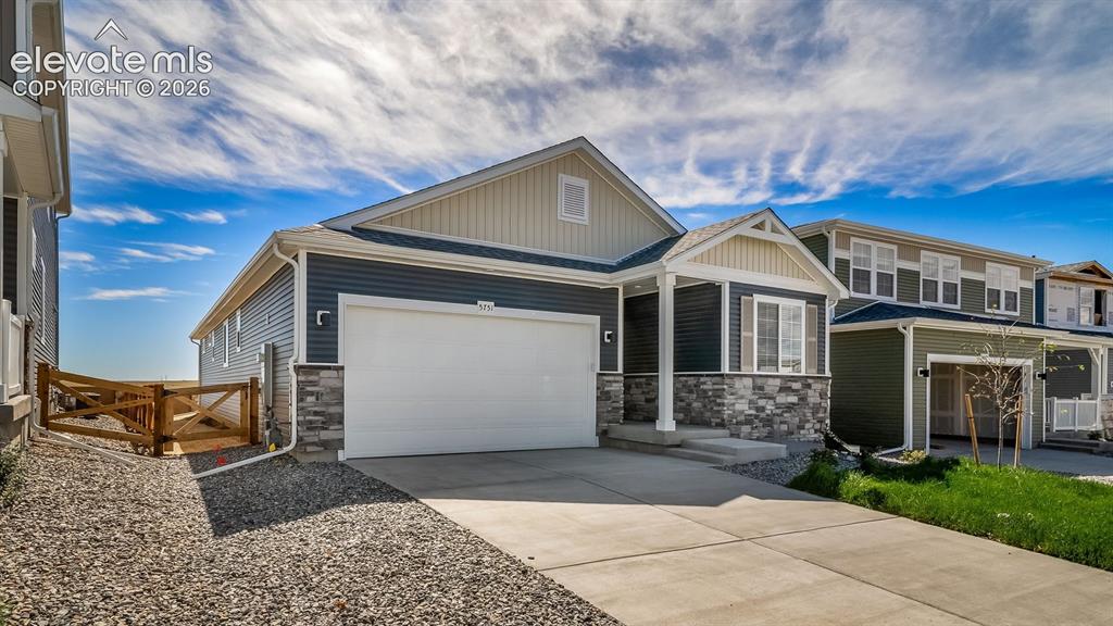 Image 1 of 47: Two-car garage with a concrete driveway, covered front porch, and a stone a