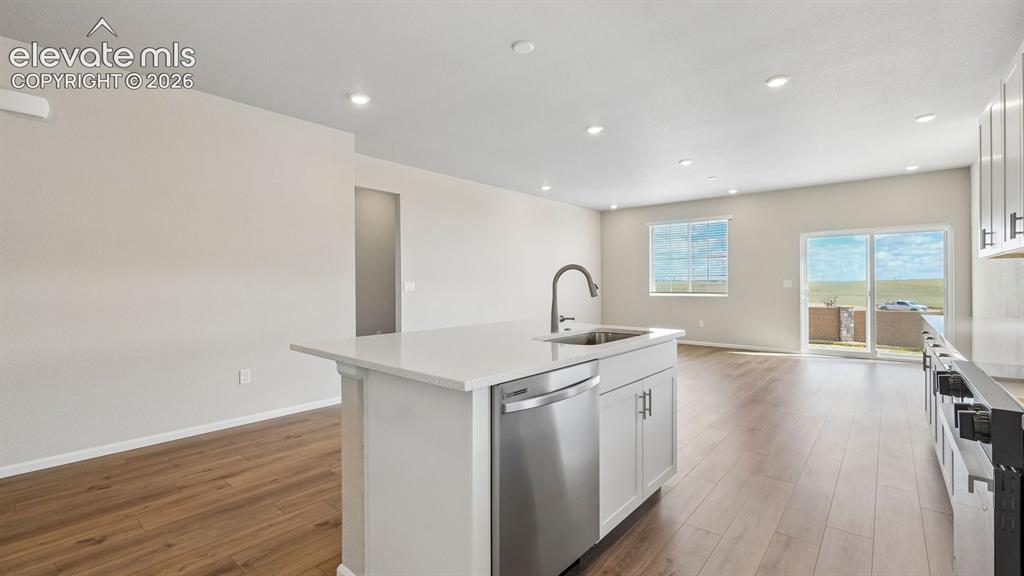 Image 11 of 47: Open-concept living area featuring wood-finish flooring, recessed lighting,