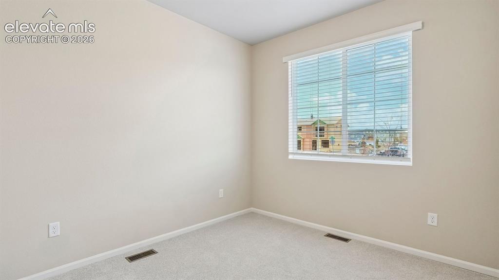 Image 12 of 47: Neutral tone wall paint, light-colored carpeting, a window with horizontal 