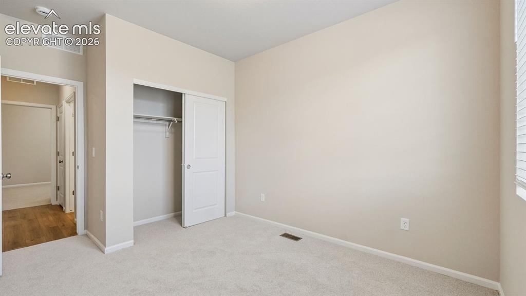 Image 13 of 47: Plush carpeting, sliding closet doors, and neutral wall tones