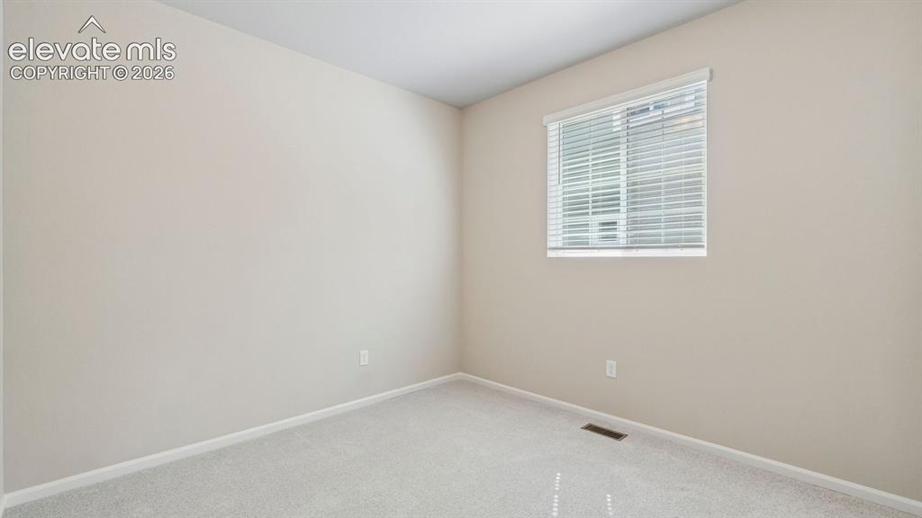 Image 18 of 47: Neutral-toned wall finish, light-colored carpet flooring, single window wit