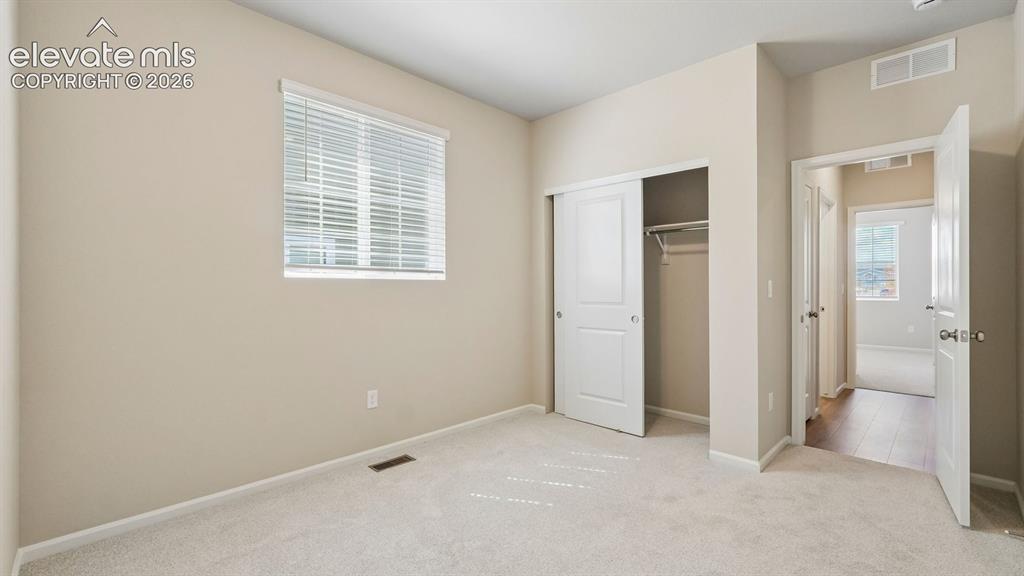 Image 19 of 47: Neutral wall color palette, carpet flooring, a window with blinds, and a cl