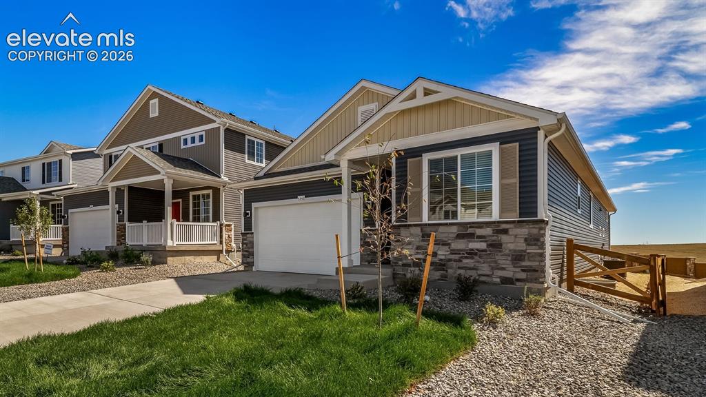 Image 2 of 47: Contemporary siding exterior with stone accenting, an attached garage, and