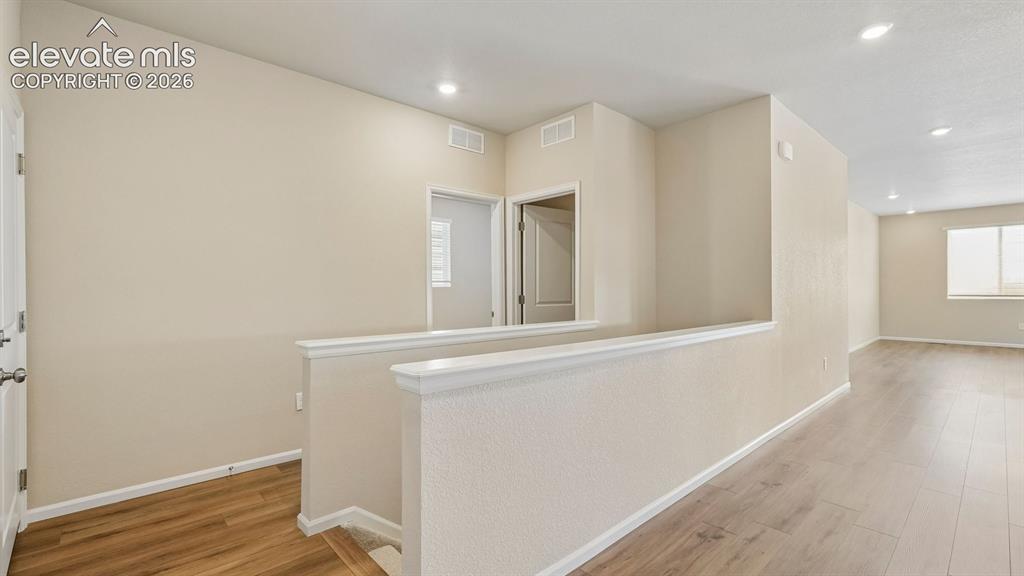 Image 21 of 47: Upper level hallway featuring wood-finish flooring, recessed lighting, and