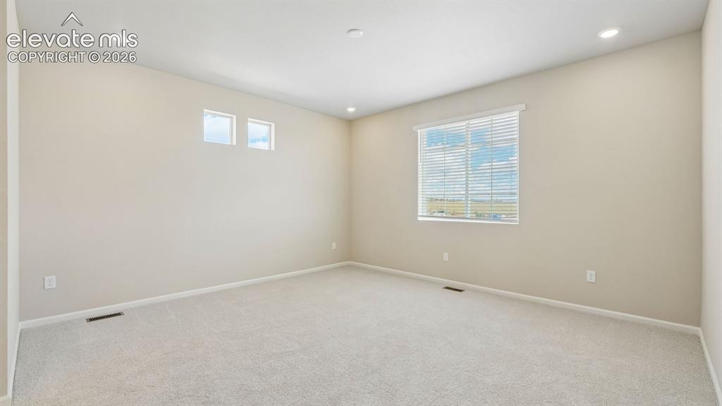 Image 27 of 47: Neutral wall paint with recessed lighting, light-colored carpeting, multipl