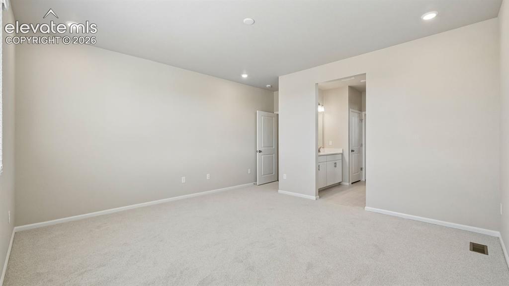Image 29 of 47: Recessed lighting, light-toned carpeting, and neutral wall tones