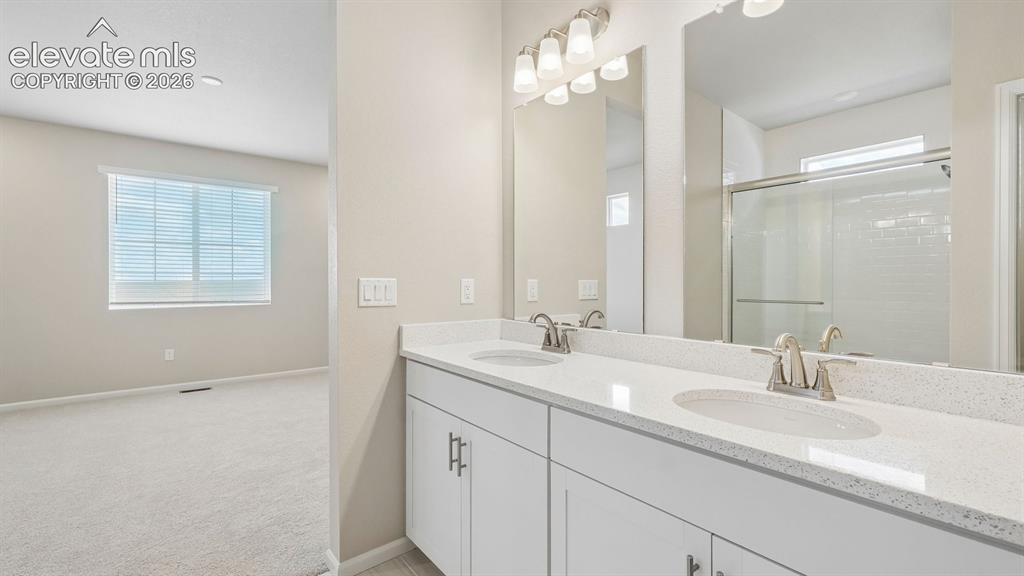 Image 31 of 47: Double vanity with integrated sinks, brushed nickel fixtures, and a glass-e