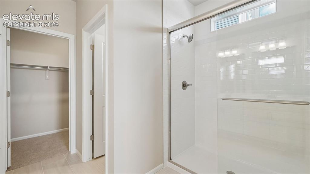 Image 32 of 47: Walk-in shower with clear glass enclosure, white subway tile surround, and 