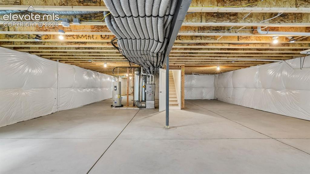 Image 34 of 47: Unfinished basement with concrete flooring, exposed wood joists, and insula