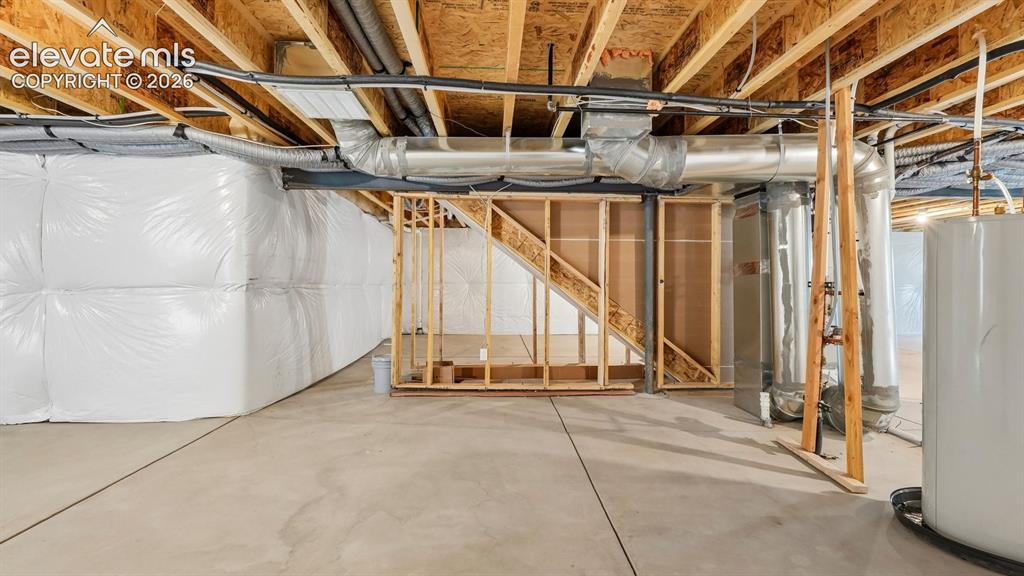 Image 37 of 47: Unfinished basement featuring exposed wood joists, concrete flooring, and c