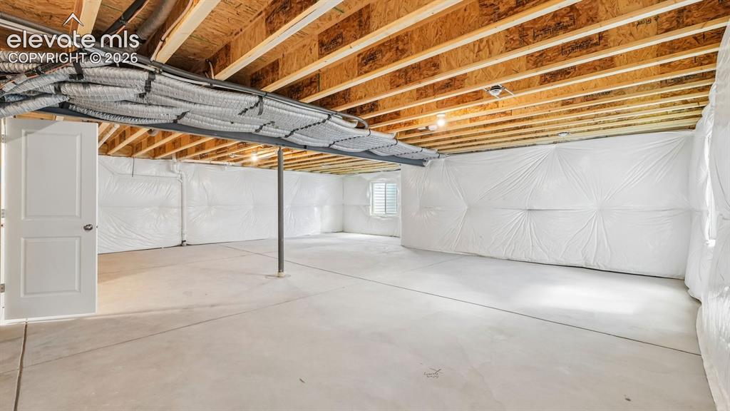 Image 38 of 47: Unfinished basement with exposed ceiling joists, concrete flooring, and ins