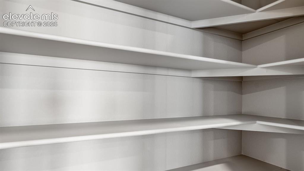 Image 4 of 11: Built-in shelving system with white finishes, providing extensive storage o