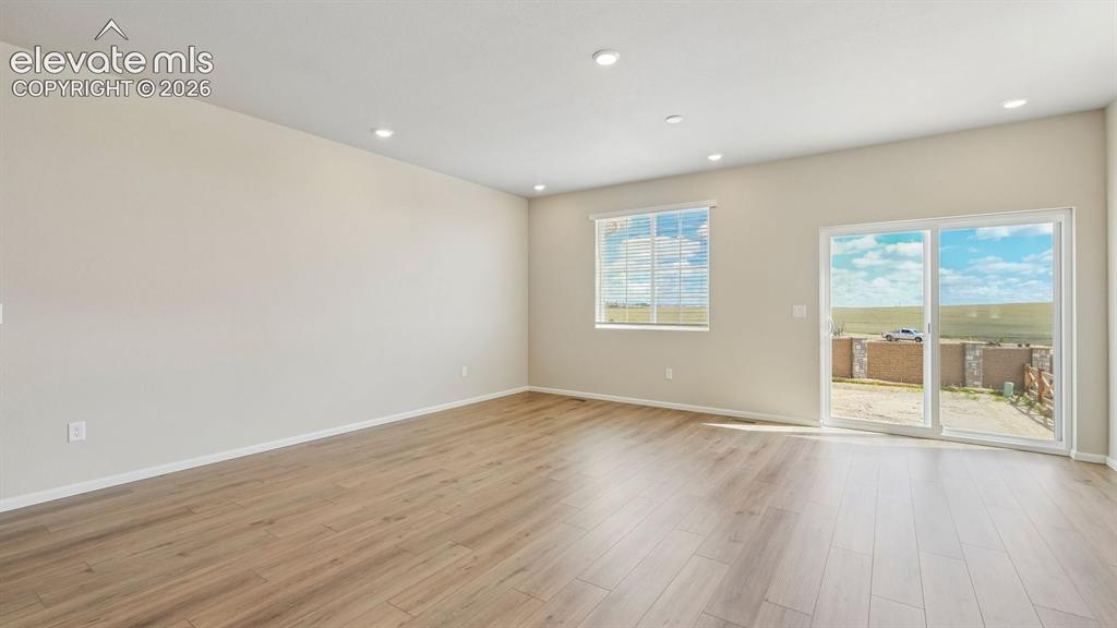 Image 4 of 47: Recessed ceiling lighting, wood-finish flooring, sliding glass door, and a
