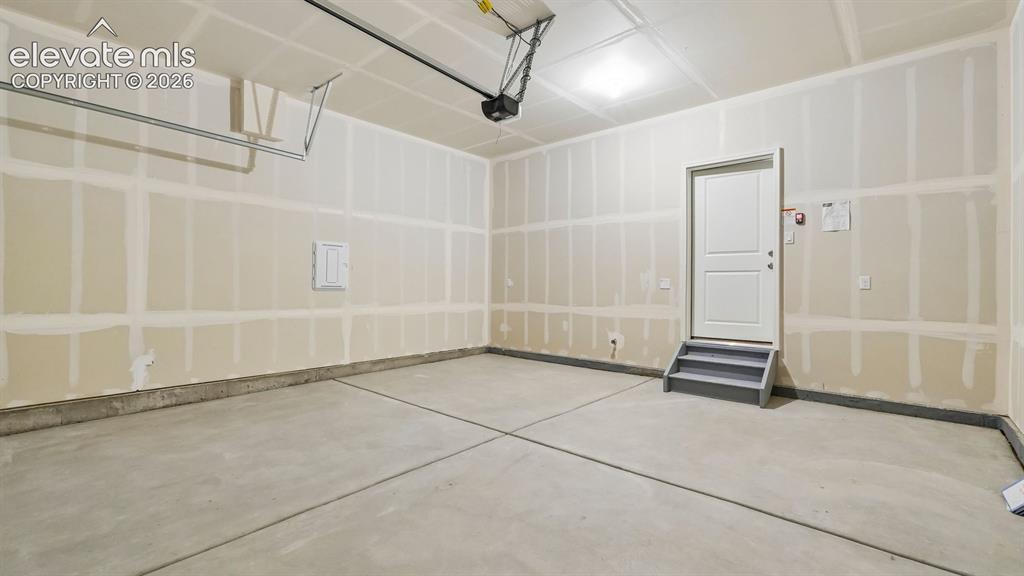 Image 40 of 47: Concrete flooring with perimeter base, overhead lighting, and interior acce