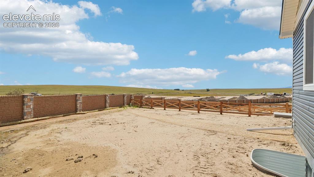 Image 45 of 47: Brick and stone-clad privacy wall with a wood-finish fence