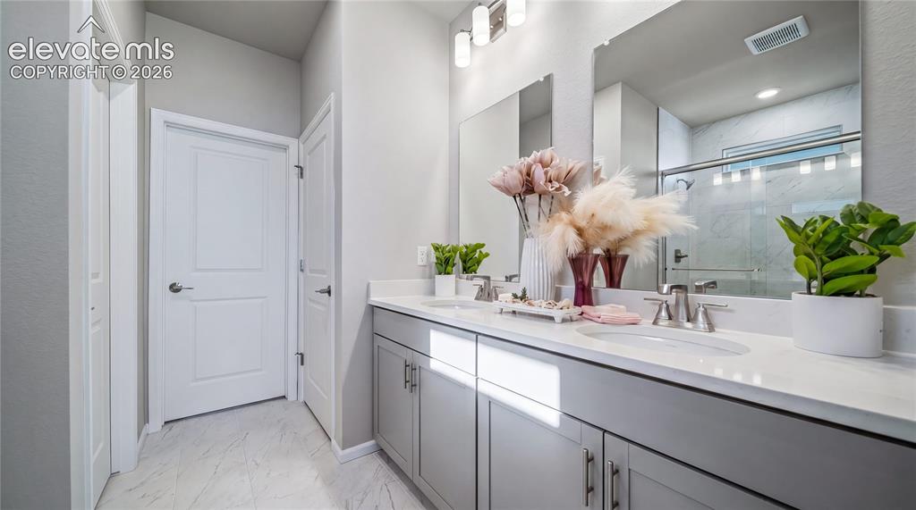 Image 8 of 11: Double vanity with light gray cabinetry and white countertops