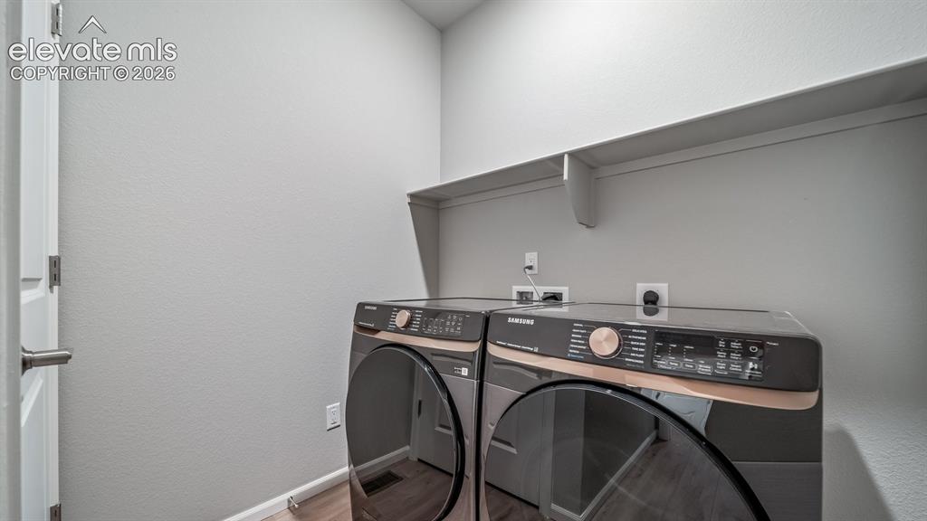 Image 9 of 11: Dedicated laundry area featuring a white wall shelf, light gray wall paint,