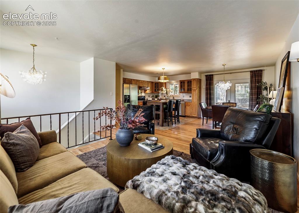 Image 4 of 48: Open-concept living area featuring wood-finish flooring, a kitchen with woo
