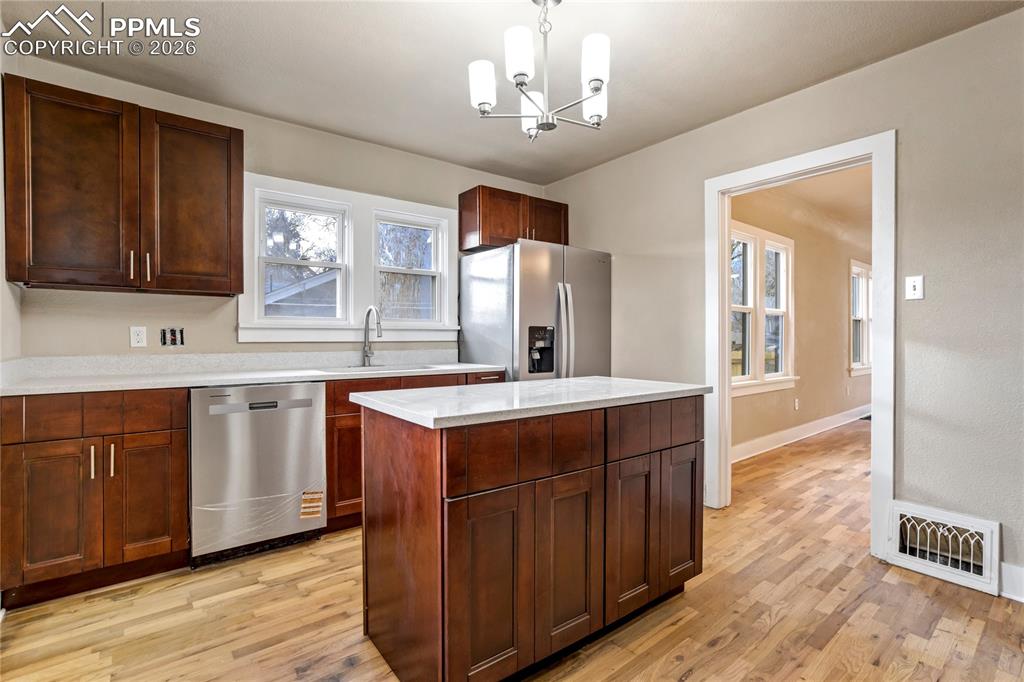Image 10 of 28: Bright kitchen with center island, stainless steel appliances, granite coun