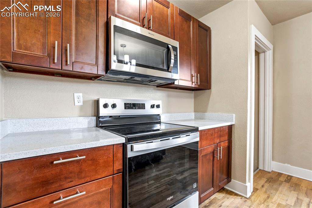 Image 9 of 28: Bright kitchen with center island, stainless steel appliances, granite coun