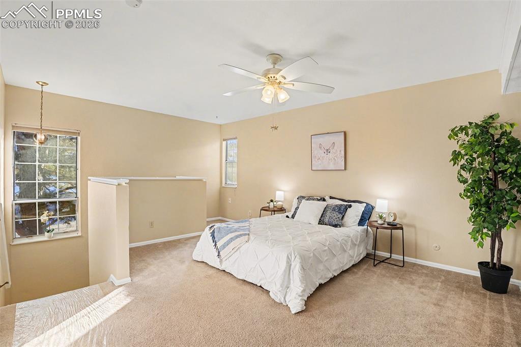 Image 16 of 29: Spacious and bright primary bedroom located on the upper level, featuring a