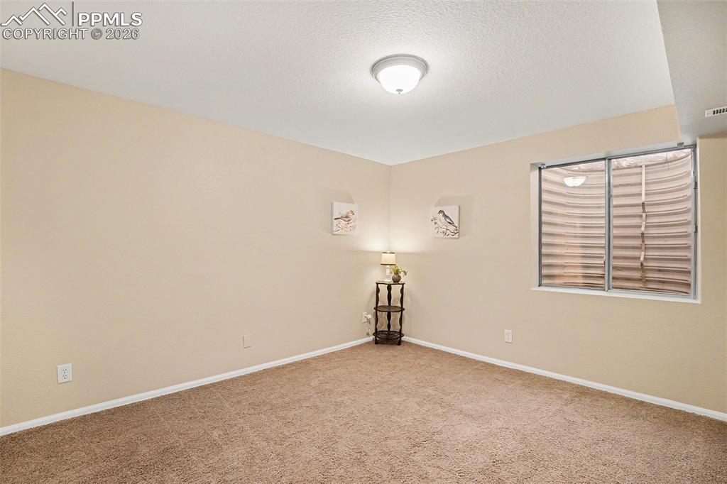 Image 22 of 29: Spacious basement bedroom, perfect for guests, with convenient access to a 