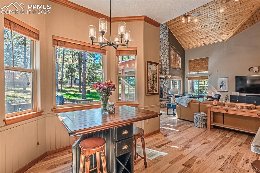 Image 11 of 50: Dining space with light wood-type flooring, a textured ceiling, wainscoting